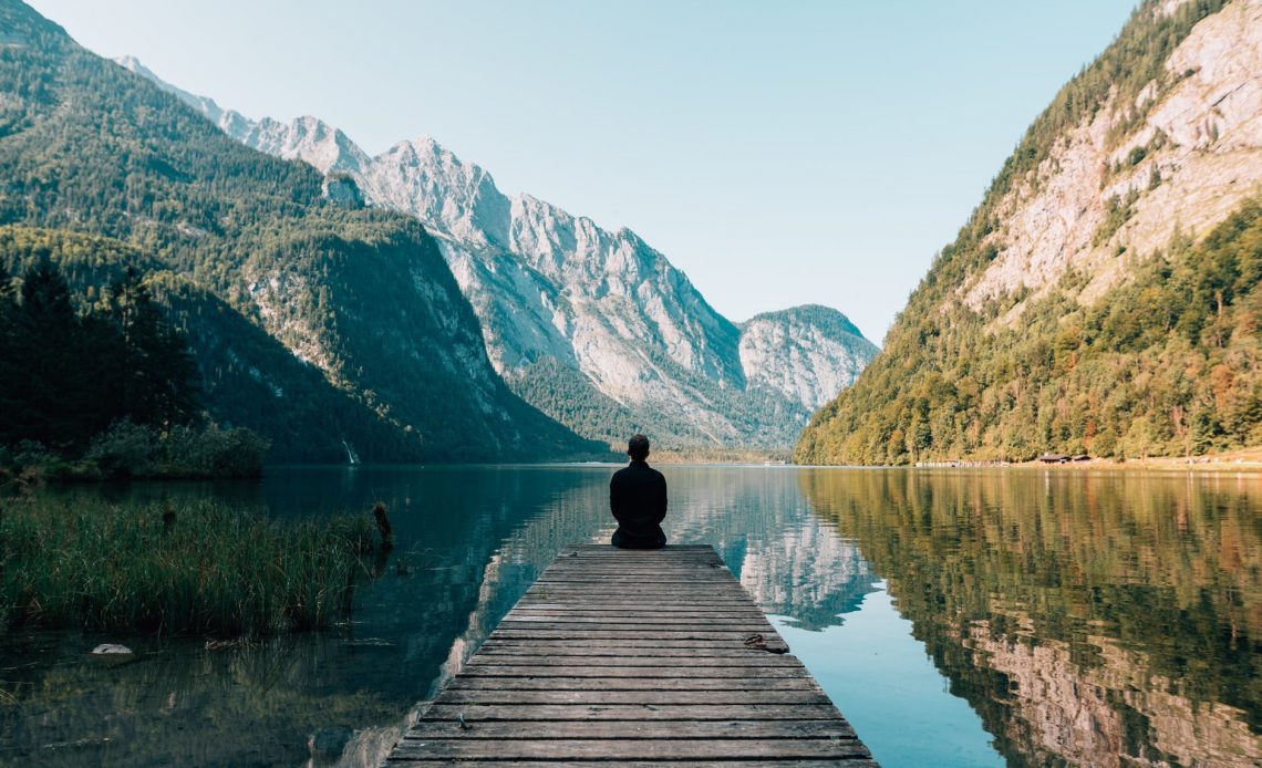 person on a bridge near a lake