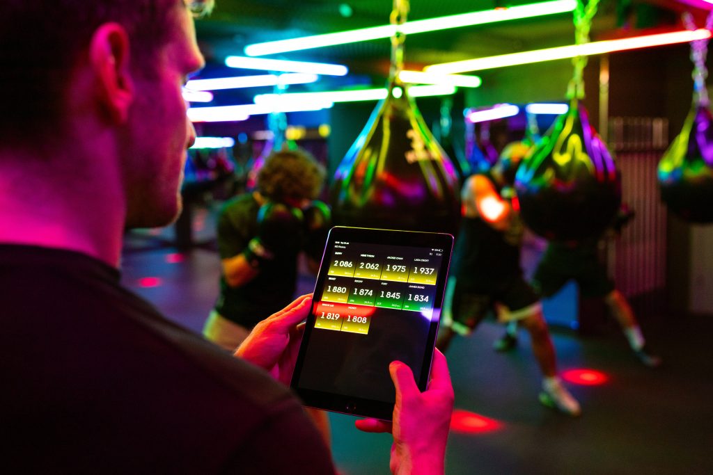 7 Proven Ways To Improve The Productivity Of Mobile App Development - a person holding up a tablet device which shows some numbers in yellow green and red blocks on it